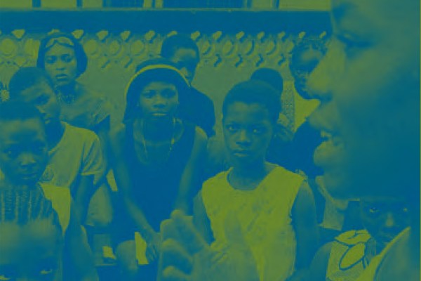 A group of people, primarily children and young adults, are gathered in a room. The image has a blue and yellow duotone filter over it, giving it an intense, graphic feel.