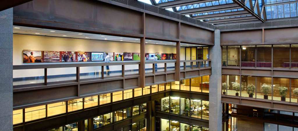 The 11th floor overlook of the Ford Foundation. The hall is decorated with a row of colorful photos and LCD screens.