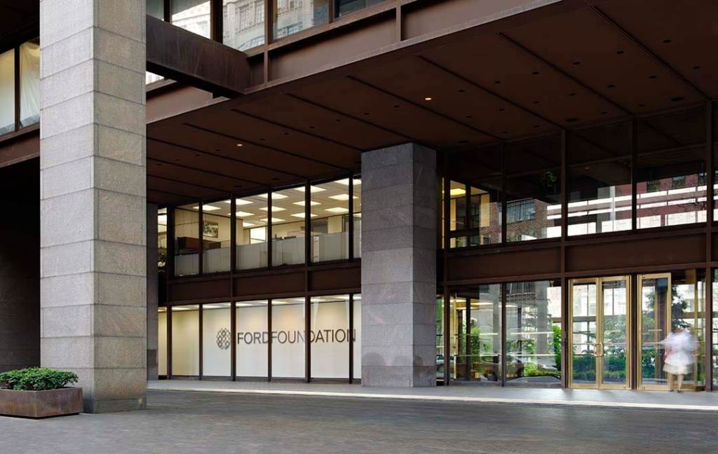 Exterior of the Ford Foundation building. The Ford Foundation logo can be seen through the glass at the front of the building.