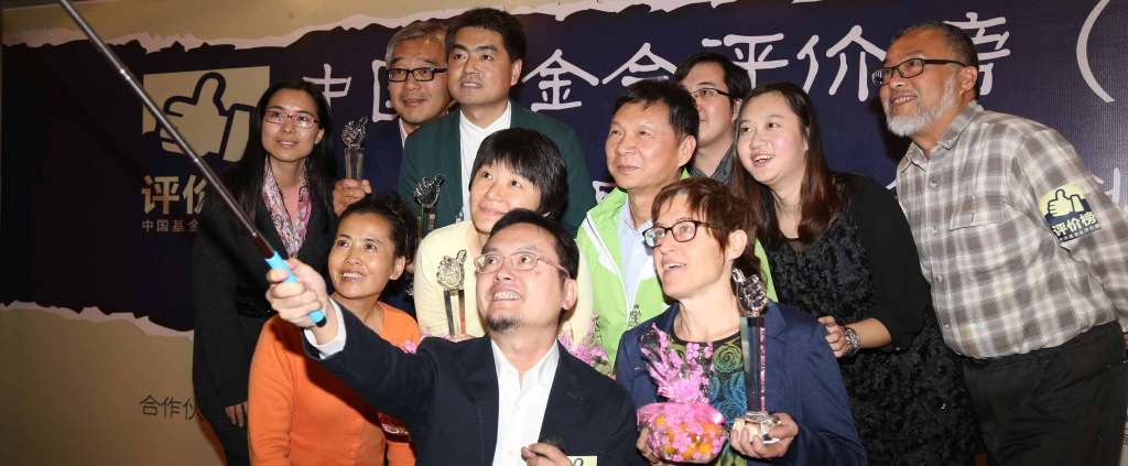 Eleven Kumquat Prize winners pose for a picture as one in the front holds a selfie stick.