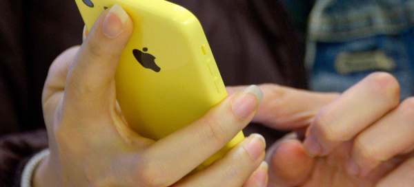 Close up of a person's hands holding a yellow iPhone. 