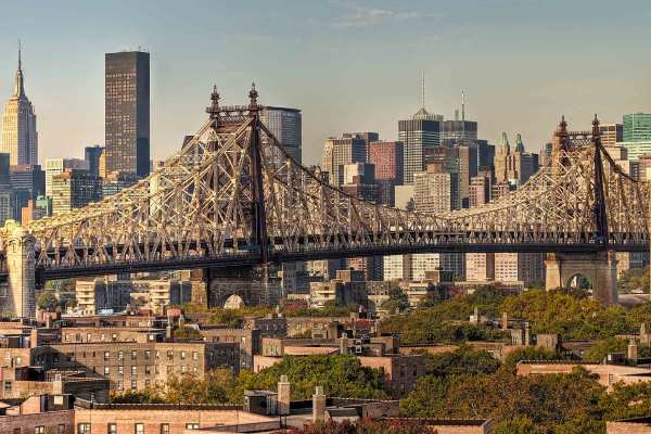 The New York City skyline with a bridge in the foreground and skyscrapers in the background.