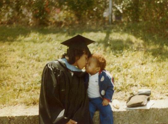 Mother in Cap and Gown embracing her child