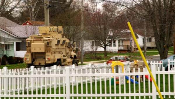 Military grade tank on suburban street. This image is unavailable under the 4.0 Creative Commons license.