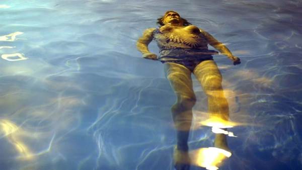 Young woman floating on her back in pool. This image is unavailable under the 4.0 Creative Commons license.