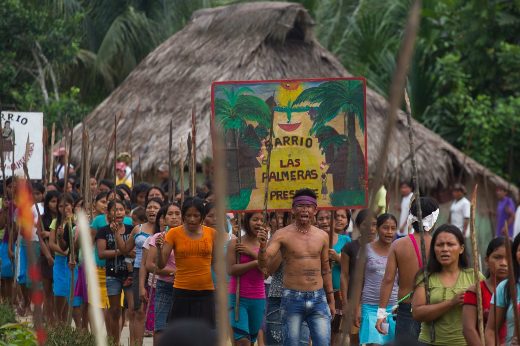 Group of indigenous people holding protest signs. This image is unavailable under the 4.0 Creative Commons license.