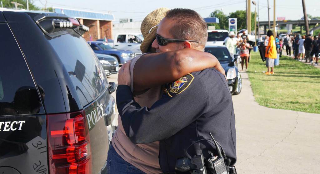 A person hugs a cop.