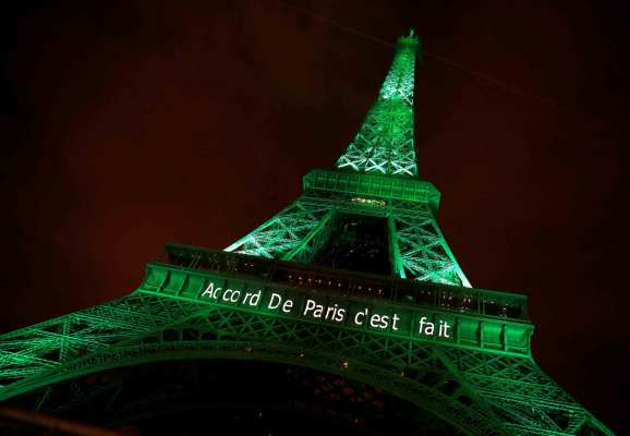 The Eiffel Tower is illuminated with green light and the words "Accord De Paris c'est fait."