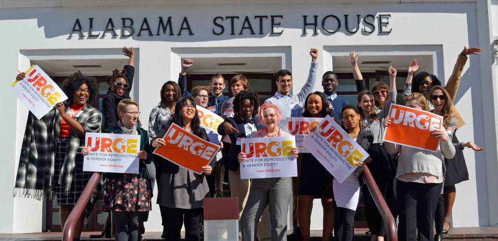 URGE’s Kierra Johnson and supporters holding "URGE" signs in front of the Alabama State House.