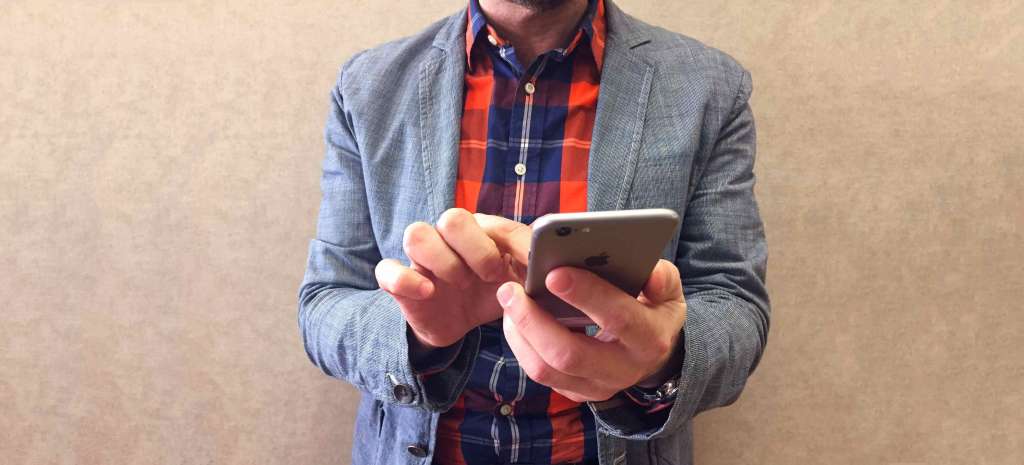 Young man typing on his smart phone.