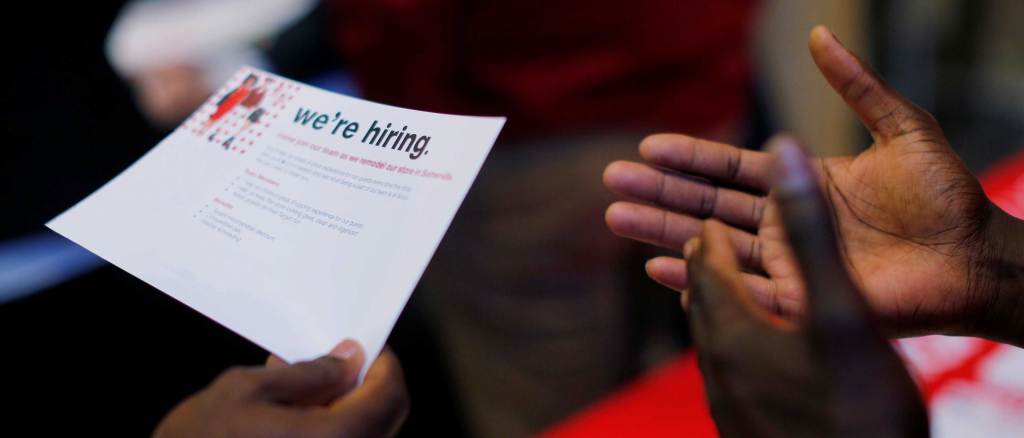 A job seeker holds a "We're Hiring" card at a City of Boston Neighborhood Career Fair. Credit: REUTERS/Brian Snyder