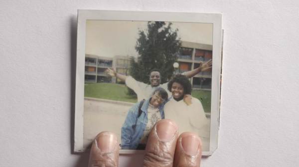 Fingers touching photo of family smiling