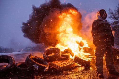 Young person in front of burning tires