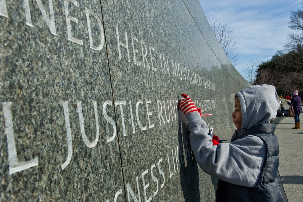 Boy in front of "The Civil Rights Memorial Center" wall in Montgomery, Alabama.