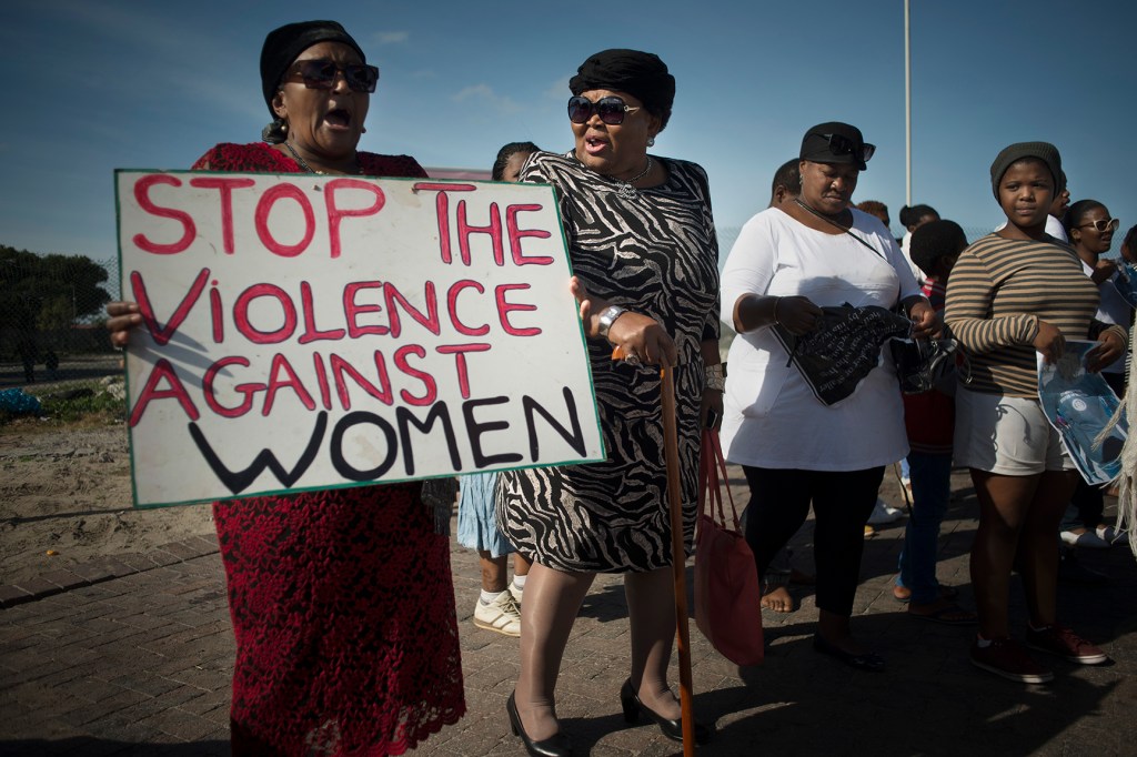 Women hold signs during a protest against violence against women, in Gugulethu.