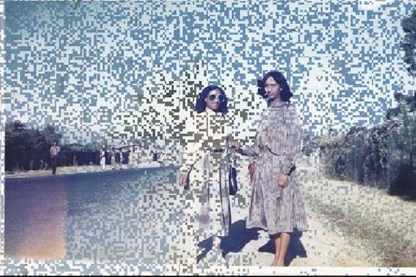 Two women standing against a glitchy background