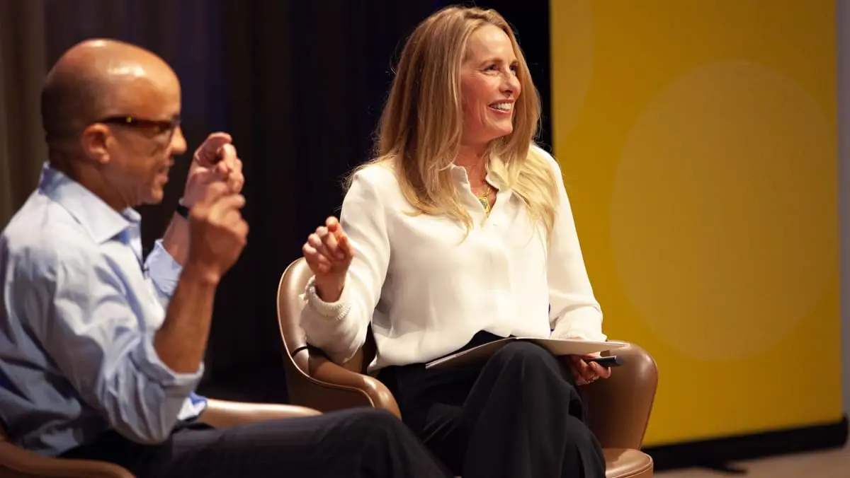 Laurene Powell Jobs sits laughing next to Darren Walker.