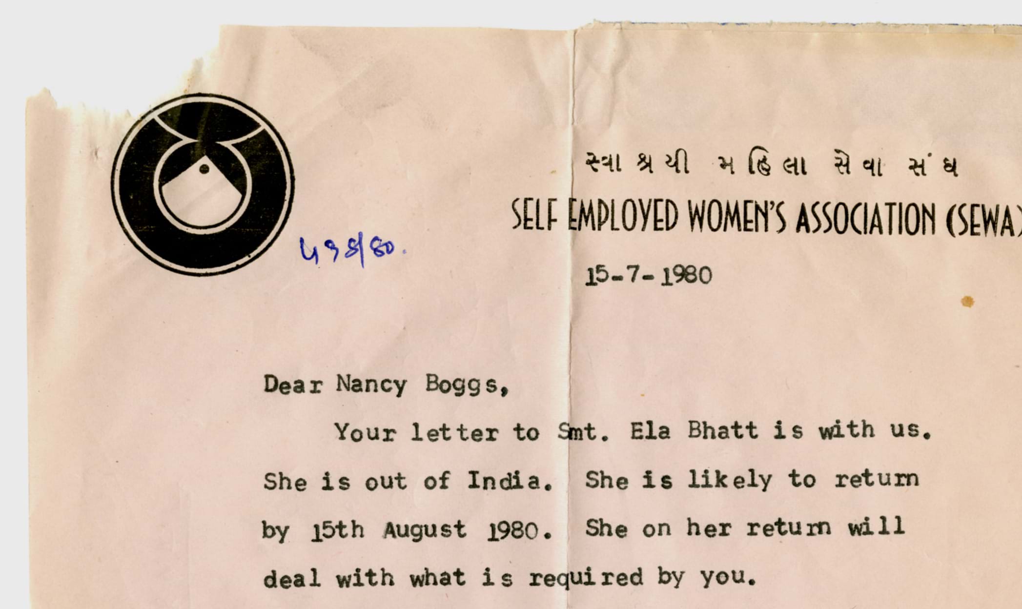 A close up of a typewritten document on Self Employed Women's Association letterhead that reads, "Dear Nancy Boggs, Your letter to Ela Bhatt is with us. She is out of India. She is likely to return by 15th August 1980. She on her return will deal with what is required by you.