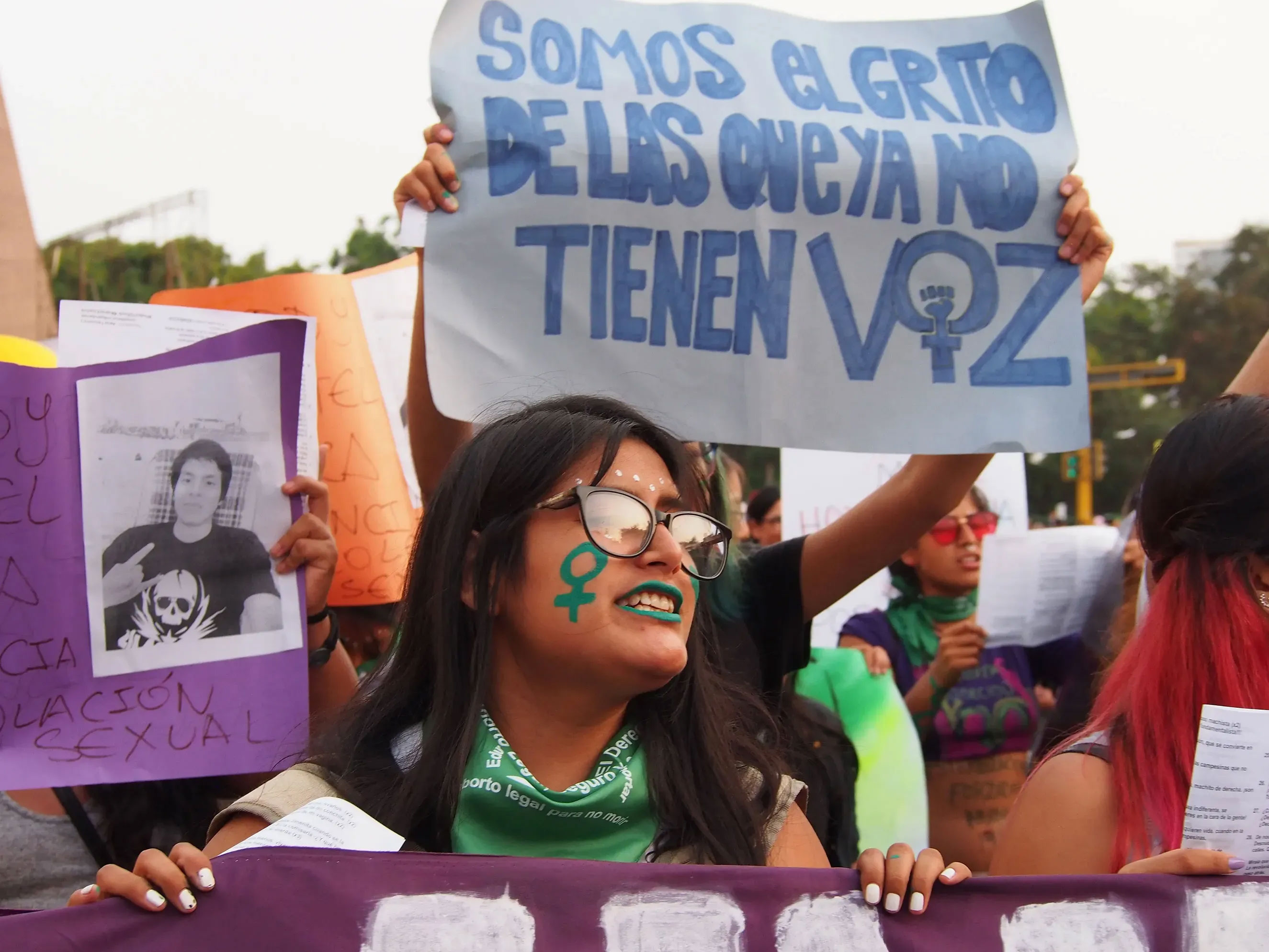 A girl with a green feminist symbol painted on her face when thousands of women from feminist and sympathetic groups take to the streets in Lima, Peru