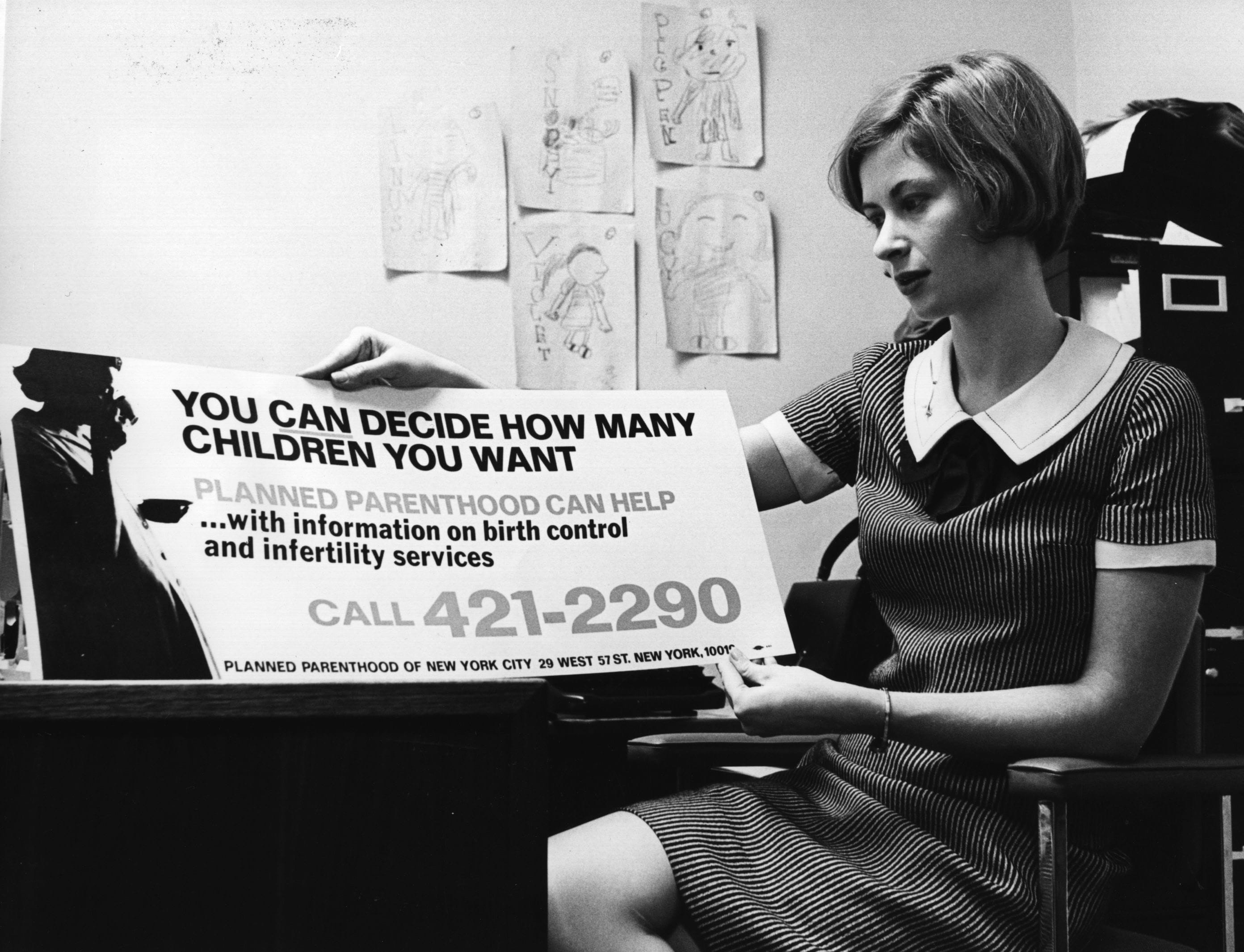 A black and white photo of a white person with a short bob wearing a dress holding an advertisement for Planned Parenthood.