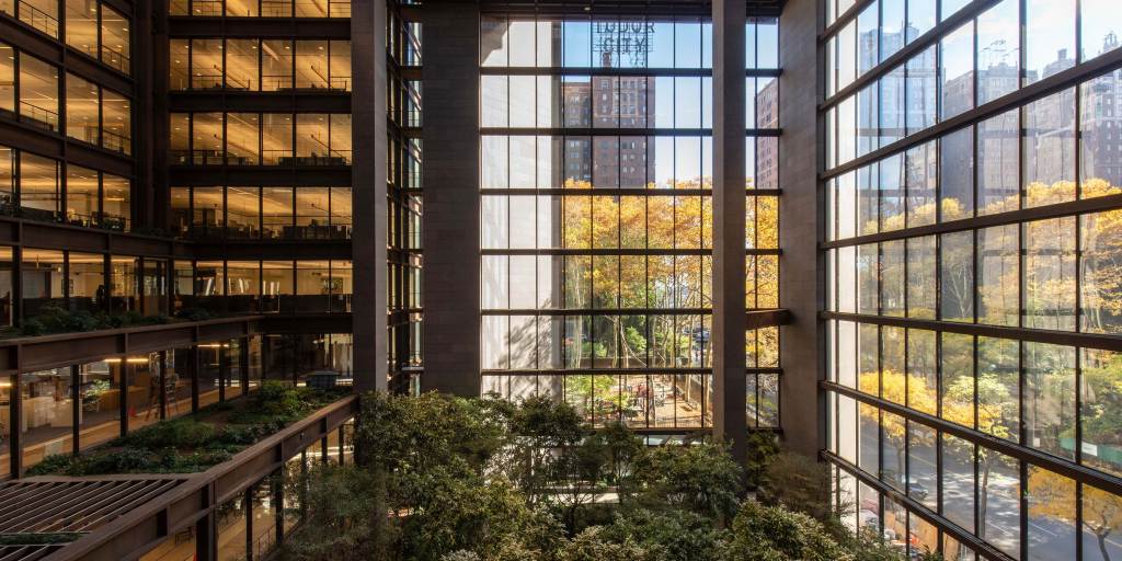 The Ford Foundation Building atrium with a view from the windows of trees with yellow leaves.