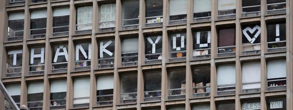 "Thank you!" spelled out with sheets of paper taped to the windows of an NYC building.