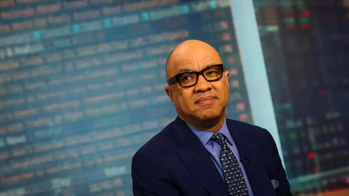 Darren Walker in front of a digital screen.