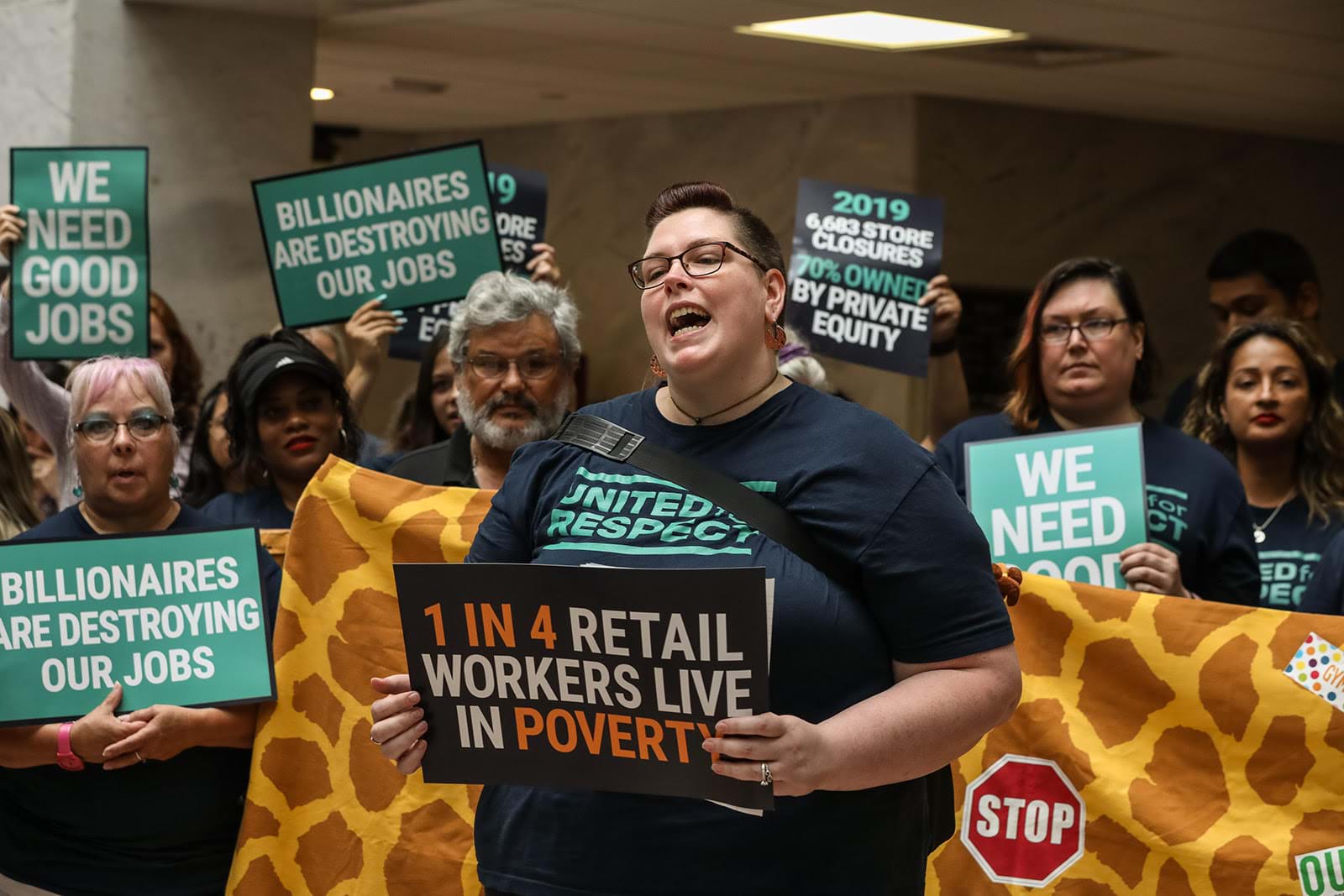 Protestors push Toys "R" Us to prioritize laid-off employees in rehires, rethink the layout of new stores, and institute a $15 minimum wage.