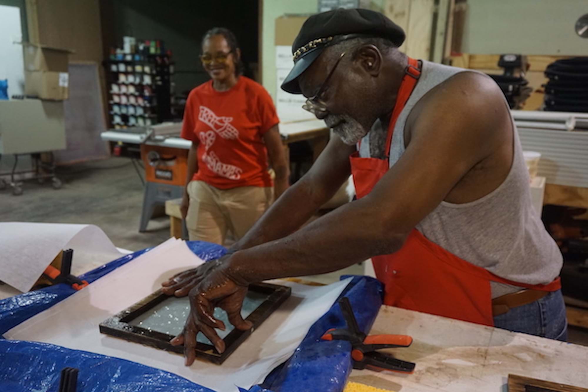 A man in a red apron makes paper from shredded criminal records with the People’s Paper Co-op. August 2019.