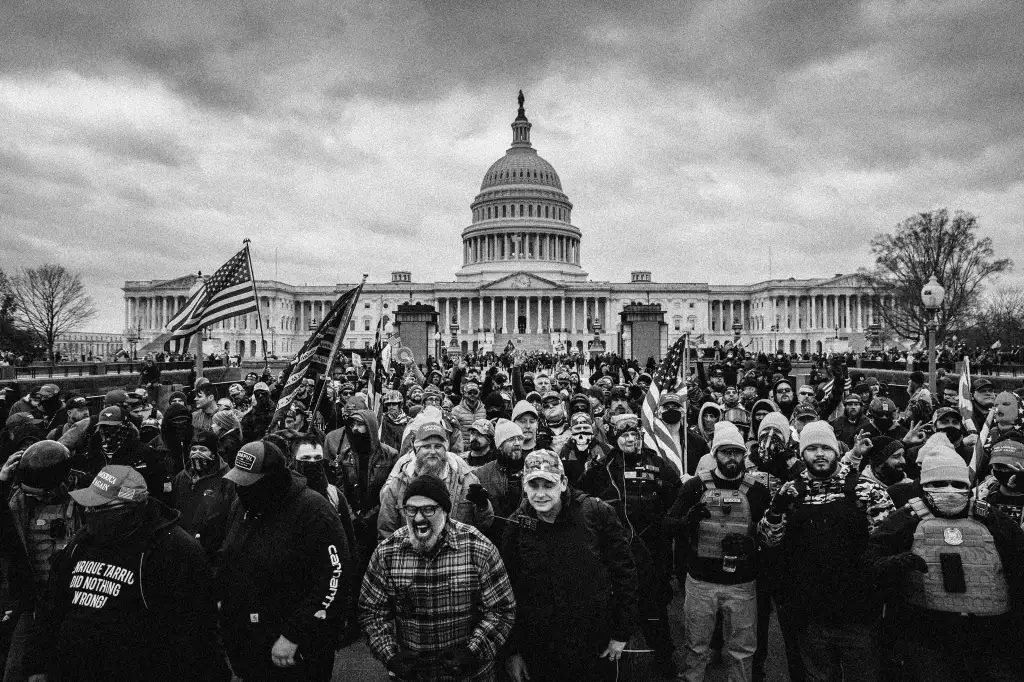 A pro-Trump mob gathers in front of the US Capitol Building on a cloudy day. Photo Jon Cherry/Getty Images.
