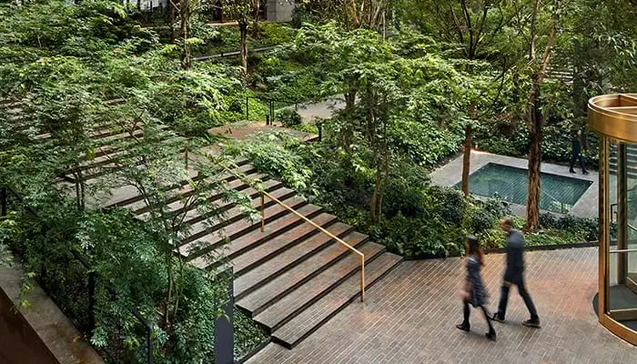 Two people walking into the Atrium at the Ford Foundation Center for Social Justice building.