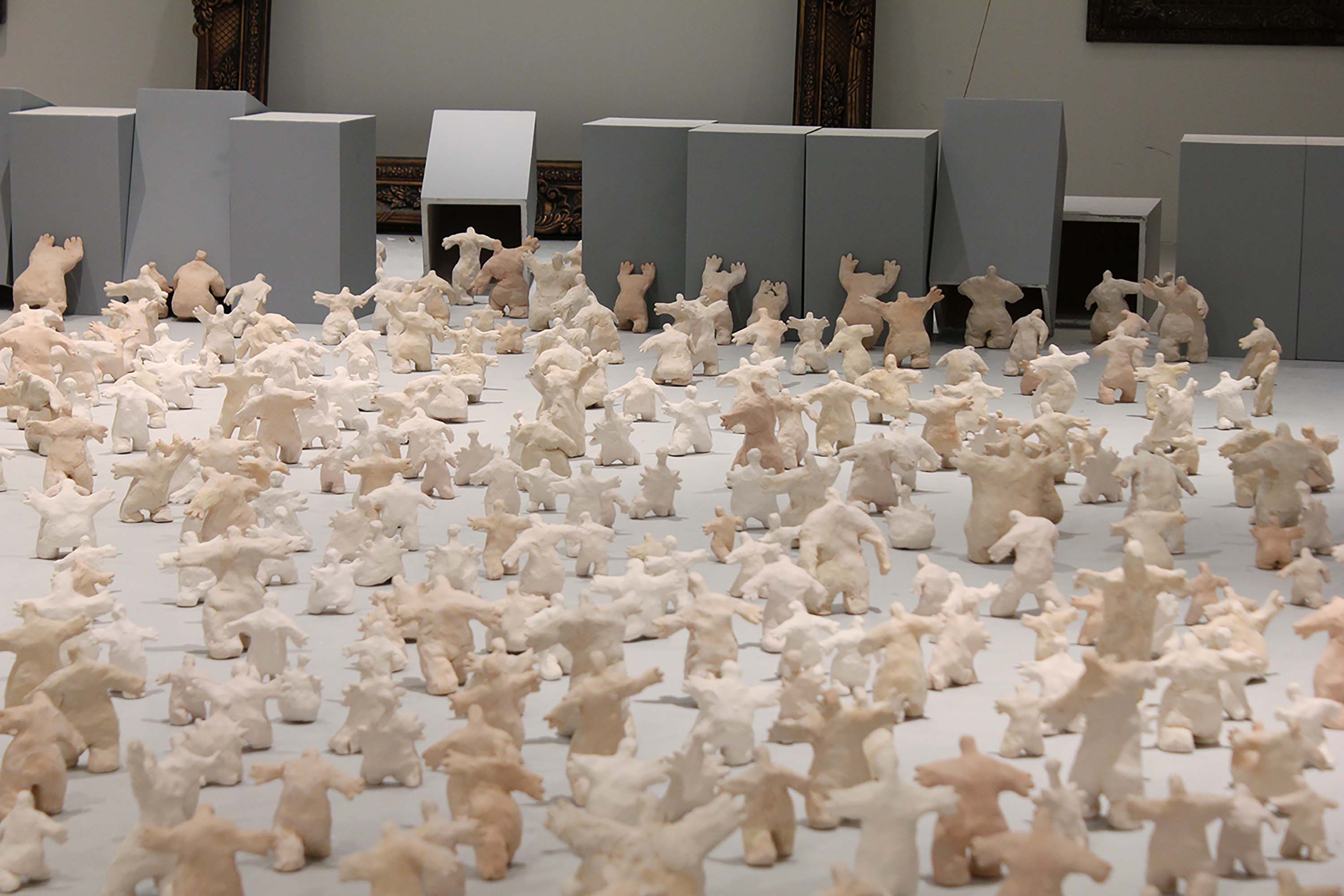 A gallery space with figurines knocking over grey columns.