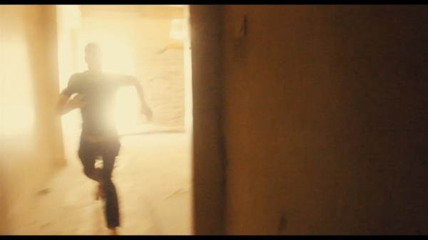 A photograph of a backlit man running