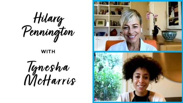 Hilary Pennington has short hair with blond highlights and is wearing a white top and sitting on an orange chair. Tynesha McHarris has a black curly hair hair, is wearing a white and black top and is wearing hoop earrings.