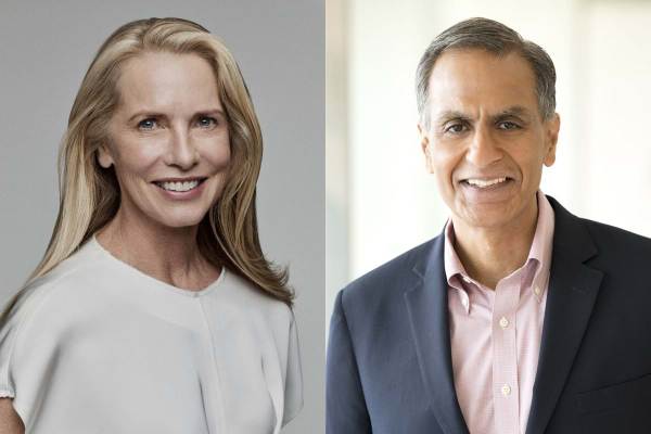 Laurene Powell Jobs wears a white blouse and is to the left of Ambassador Richard Verma who is wearing a navy suit jacket and light red checkered collared shirt.