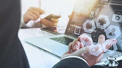 Image of a man's hand pointing at a laptop with some iconography superimposed on it.