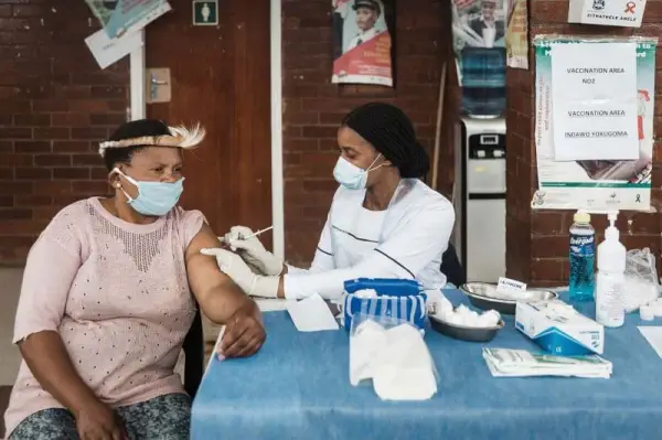 Nurse giving a COVID vaccine to a female patient.