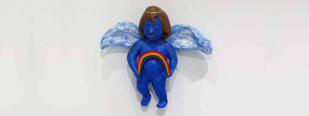 A blue-child figure with white wings and a painted gold headband holding a rainbow