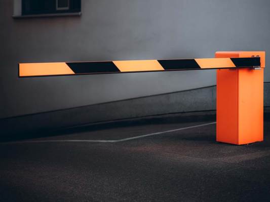 An orange and black toll gate