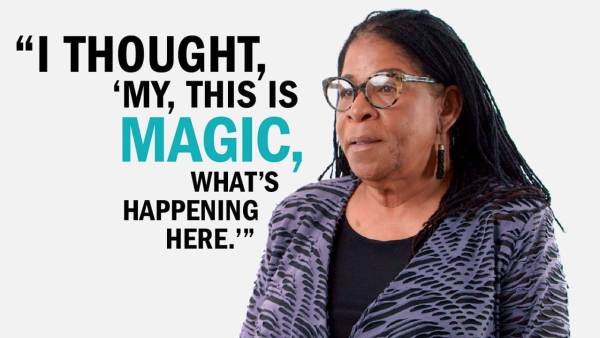 Susan Burton has black braids and is wearing thick-rimmed glasses and black earrings. She wears a purple top over a black blouse. She's standing next to copy that reads, "I thought 'my, this is magic. What's happening here.'"
