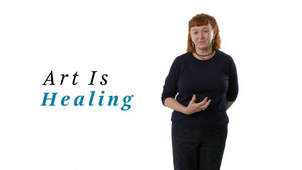 Deborah Luster, a white woman, is wearing a black crew neck top and black trousers. The phrase "Art Is Healing" appears to her left.