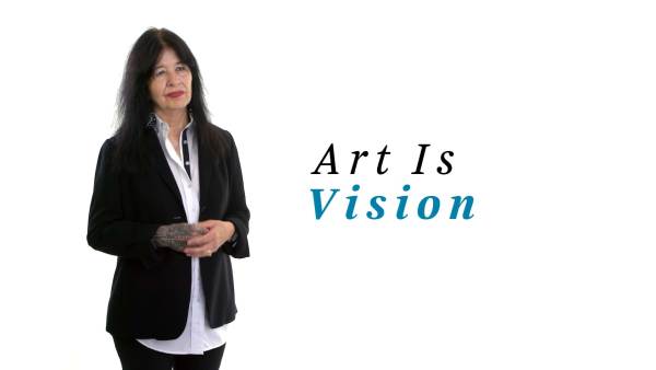 Joy Harjo, in a white button-down shirt with black trim, a black blazer, and slacks. The phrase "Art Is vision" appears to the right.