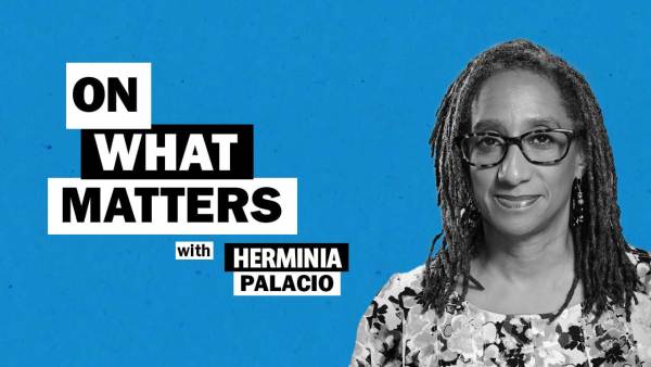 Dr. Herminia Palacio has shoulder-length dreaded hair locks and is wearing dark-rimmed glasses and a floral print dress. To her left appears the text: On what matters with Herminia Palacio.