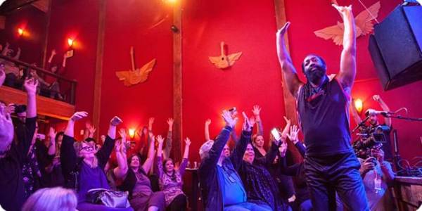 Antoine Hunter, right, an African-American dancer who is deaf, leads the audience at the Northwest Deaf Arts Festival, an event produced by CymaSpace, one of the first Disability x Tech grantees.