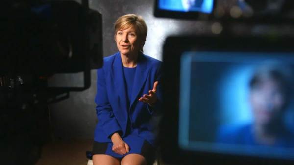 Sue Desmond-Hellman sitting on a film set in front of cameras.