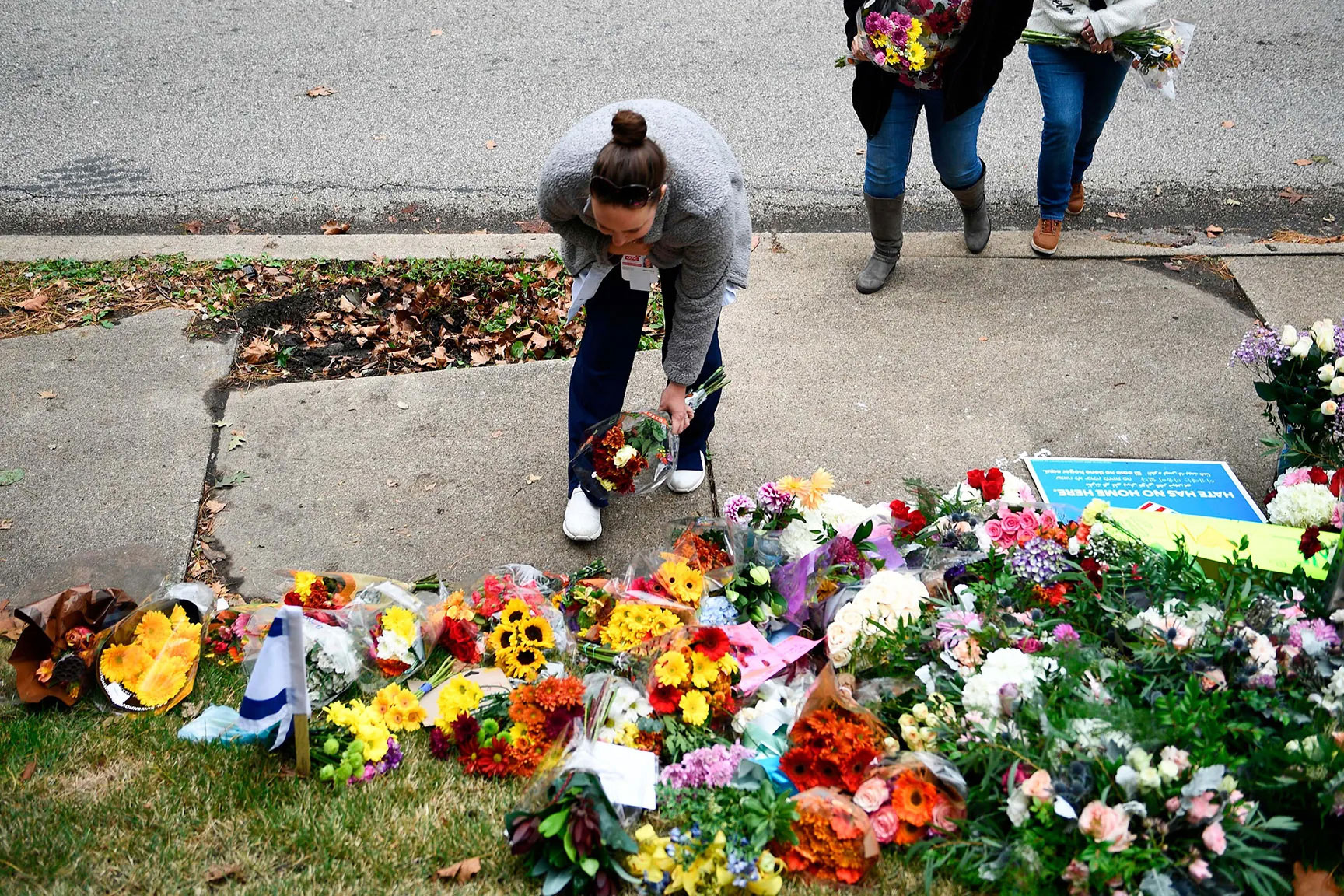 Women lay flowers at a memorial on October 28, 2018, down the road from the Tree of Life synagogue.