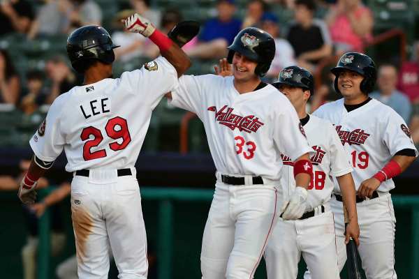 Minor League baseball players from the Tri-City ValleyCats' AJ Lee gets a high five from teammates.