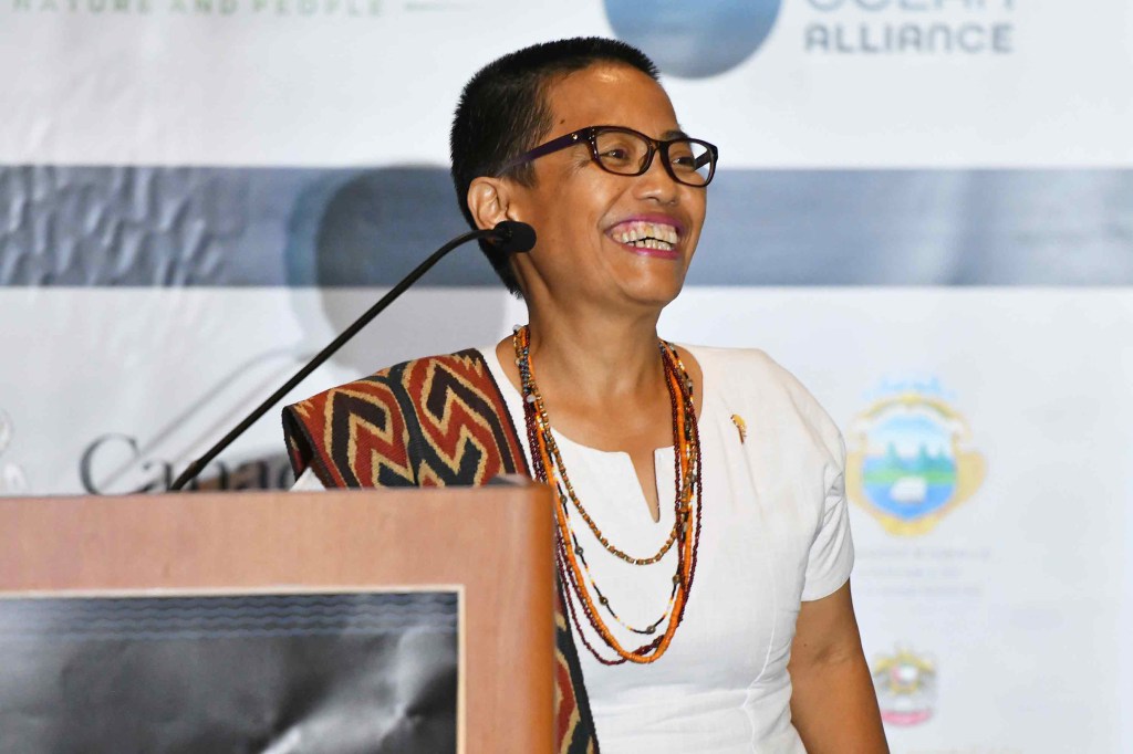 Image of a woman in glasses and a white shirt smiling.