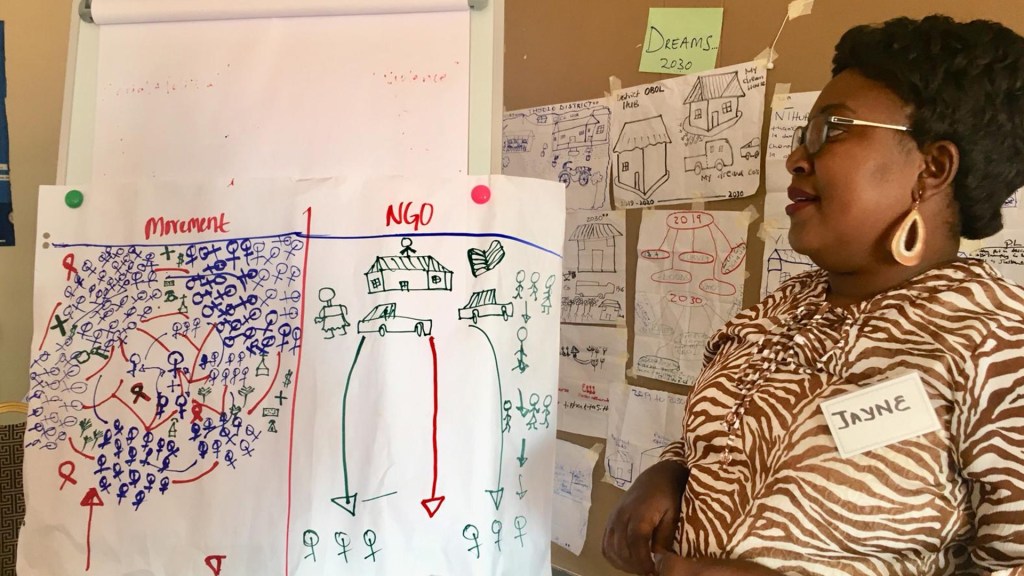 Jayne Jalakasi referring to a white board while teaching a session.