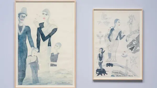 Two framed watercolor illustrations in vertical orientation hanging side by side on a light blue wall.